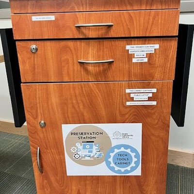 Brown locked cabinet with a "Preservation Station" sign on the front