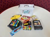 Rush Hour, Bananagrams, Taco vs. Burrito, Uno, Set, and Spot It! games on a white table top
