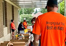 Volunteers working the donation tables for the backpacks for kids program