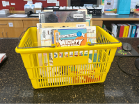 Yellow hand held basket full of books sitting on the counter