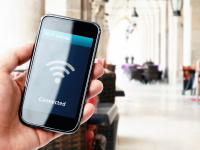 Hand holding up a phone displaying a wifi connected symbol
