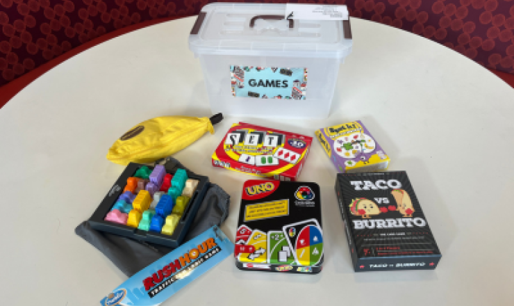 Rush Hour, Bananagrams, Taco vs. Burrito, Uno, Set, and Spot It! games on a white table top