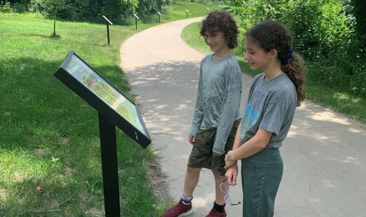 Two children reading along Storywalk at Arbor Lake